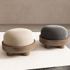 two small stools sitting on top of a white rug