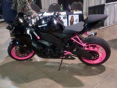 a black and pink motorcycle is on display