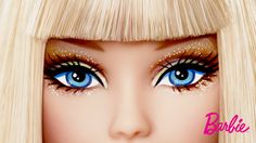 a barbie doll with blonde hair and blue eyes wearing gold glitters on her eyelashes