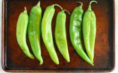 four green peppers sitting on top of a pan