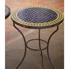 two blue and yellow patterned tables sitting on top of a floor next to each other