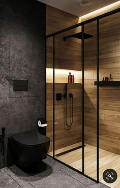 a modern bathroom with glass walls and wooden accents, along with a walk in shower