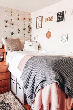 a bedroom with white walls and wooden floors, decorated with garlands on the wall