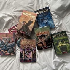 six harry potter books laid out on a white bed sheet with the covers pulled down