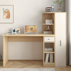 a desk with a laptop on it in front of a white wall and wooden floor