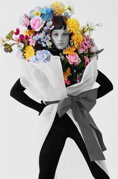 a woman with flowers on her head holding a bouquet