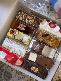 a box filled with lots of different types of desserts on top of a table