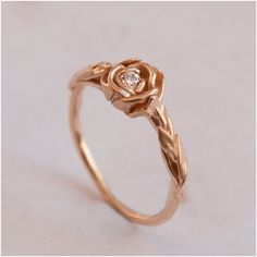 a rose shaped ring with a diamond in the center