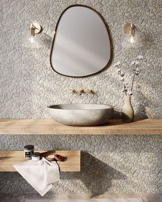 a bathroom with a sink, mirror and towel on the shelf in front of it