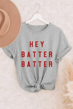 Hey Batter Batter Baseball Tee: Because baseball season is the best season. This classic fit graphic tee is unisex sizing, the lightweight fabric makes it the perfect tee for the ballpark! Pair it with some jean shorts and your team hat and you are game day ready! Material: 90% Cotton 10% Polyester Care: Machine wash warm, inside out with like colors Only non-chlorine bleach Tumble dry low Iron medium, if needed. Do not iron on decoration Do not dry clean Hey Batter Batter Shirt, Baseball Mama Outfit, Diy Baseball Shirt, Baseball Tournament Mom Outfit, Sayings To Put On Shirts, Baseball Tshirt Ideas, Elevated Tshirt, Baseball Tshirt Designs, Baseball Tee Outfit