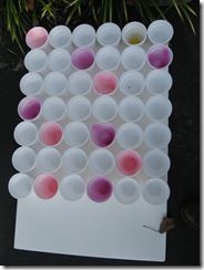 a bunch of cups that are on top of a white board with pink and purple circles