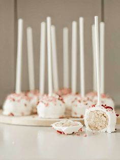 cake pops with white frosting and sprinkles on a plate