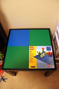 a table with legos on it in the middle of a room next to some toys