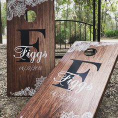 two wooden signs with lace on them sitting next to each other in front of a fence