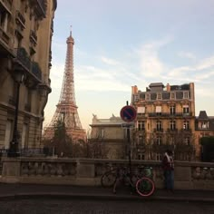 the eiffel tower is in the distance behind two bicycles