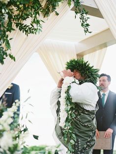 a man in a suit and tie standing under a canopy