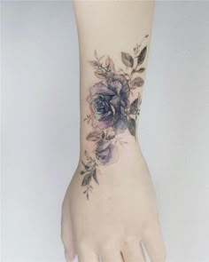 a woman's hand with a purple flower tattoo on the left side of her arm