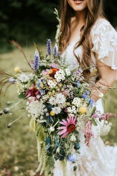 a woman holding a bouquet of flowers in her hands