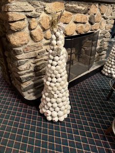 a christmas tree made out of rocks in front of a fireplace