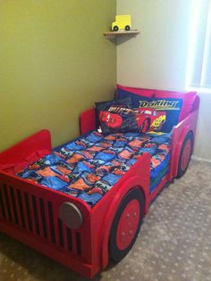 a child's bed with cars on it in a room