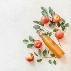 an apple cider surrounded by apples and leaves