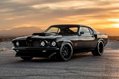 a black muscle car parked in the desert