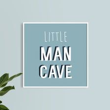 a blue poster with the words little man cave on it next to a potted plant