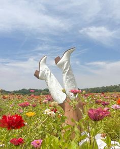 a woman's legs in the middle of a field full of flowers