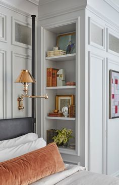 a bed sitting in a bedroom next to a tall book shelf with books on it