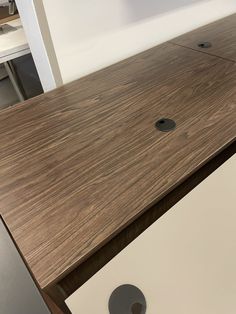 an apple computer monitor sitting on top of a wooden desk next to a white wall