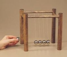 a hand is holding an abacus with three balls in it and another person's hand next to the abacus