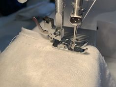 the sewing machine is working on the white material that's being sewnged