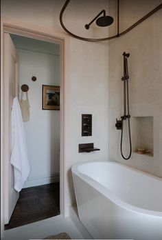 a white bath tub sitting next to a shower head