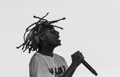 a young man with dreadlocks holding a baseball bat in his right hand and looking up at the sky