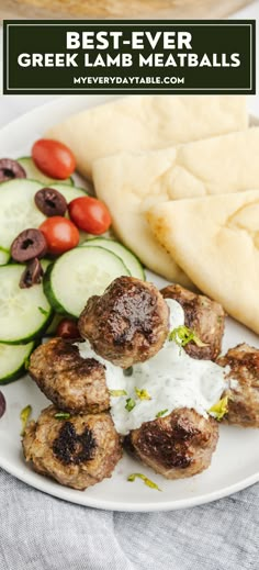 greek lamb meatballs with cucumbers, tomatoes and olives on a white plate