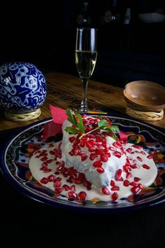 there is a dessert with pomegranates on it and a glass of wine