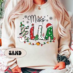 "Personalized Christmas Teacher Shirt, Xmas Teacher Name Shirt, Teacher Christmas Sweatshirt, Xmas Teacher Pattern, Christmas Teacher Gift ↓ Click here to view our additional fashionable collections ↓ https://handcraftedbyhelenn.etsy.com Product Details: - 100% Cotton (fiber content may vary for different colors) - Medium fabric (5.3 oz/yd2 (180 g/m2)) - Classic fit - Tear away label - Runs true to size Care instructions: - Machine wash: warm (max 40C or 105F); - Non-chlorine: bleach as needed; Cute Teacher Christmas Shirts, Personalized Teacher Christmas Gifts, Teacher Christmas Sweater, Teacher Team Christmas Shirts, Teacher Pattern, Christmas Teacher Gift, My Favourite Teacher, Teacher Sweatshirt, Teacher Christmas Gifts