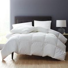 a white comforter on a bed in a room