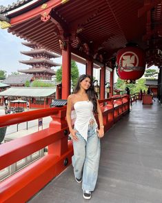 a woman standing in front of a red building