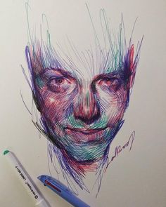 a drawing of a man's face with colored pencils on the paper next to it