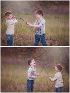 two boys are playing with an arrow in the grass and one boy is holding it up