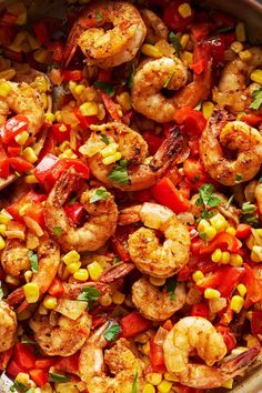 a pan filled with shrimp, corn and tomatoes