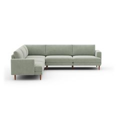 a large sectional couch sitting on top of a white floor next to a wooden leg chair