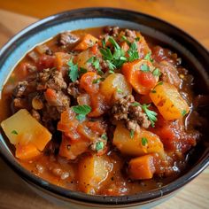 a close up of a bowl of food with meat and vegetables in it on a table