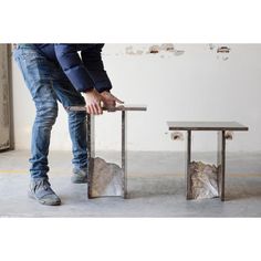 a man is bending over to put something on top of a table that has been made out of concrete