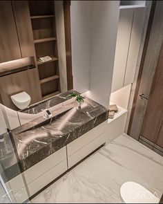 a modern bathroom with marble counter tops and white walls, along with built - in shelving