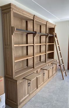 a large wooden bookcase with drawers and ladder in a room that is being remodeled