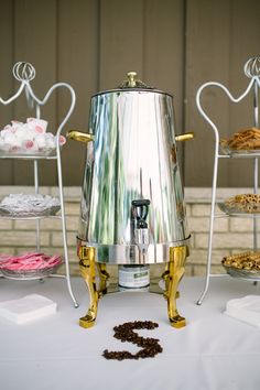 a large metal pot sitting on top of a table next to other plates and trays