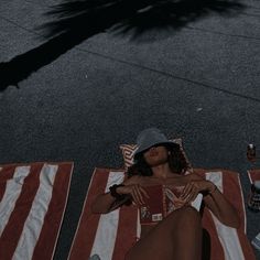 a woman laying on the ground next to an american flag blanket and bottle of booze