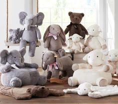 a group of stuffed animals sitting next to each other on a wooden floor in front of a window